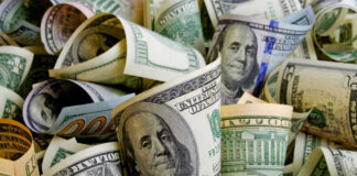 Rolled U.S. dollar bills in various denominations.