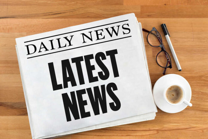 shutterstock_565653796.jpg Newspaper with headline latest news on table