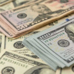 Stacks of US dollars featuring Benjamin Franklin and Ulysses S. Grant.