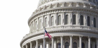 U.S. Capitol dome with American flag flying.