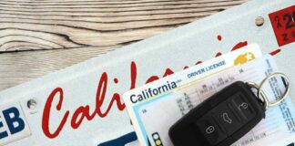 California license plate, driver's license, and car keys on a wooden surface