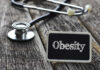 A stethoscope next to a sign that reads 'Obesity'