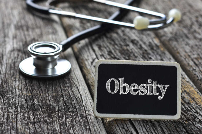 A stethoscope next to a sign that reads 'Obesity'