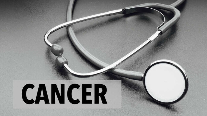A stethoscope on a dark surface with the word 'CANCER' prominently displayed