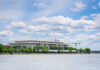 A modern building by the river under a cloudy sky