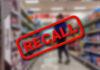 Shock Recall: Black Mystery Substance in Bottled Water Recall stamp on blurred store aisle background.