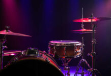 Close-up of a drum set with colorful stage lighting