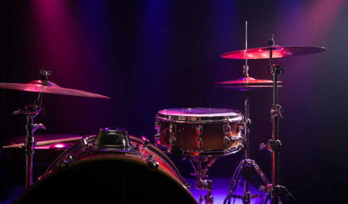 Close-up of a drum set with colorful stage lighting