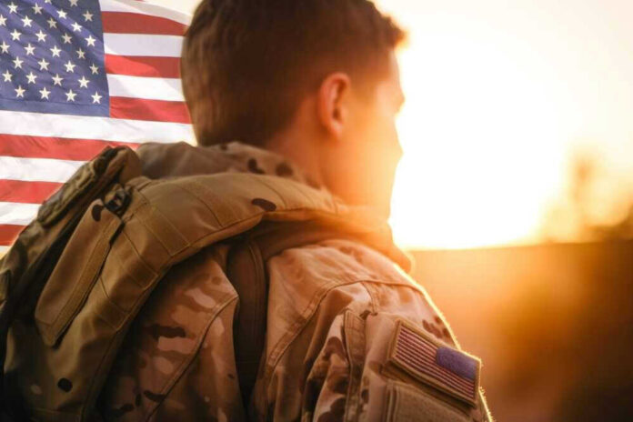 Soldier in uniform with American flag at sunset.