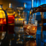 Pouring whiskey into a glass with ice