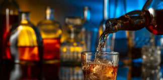 Pouring whiskey into a glass with ice