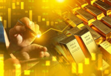 Hand writing near stacked gold bars and charts