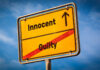 Serial Killer Identified — After Innocent Men Imprisoned A yellow road sign displaying 'Innocent' pointing up and 'Guilty' crossed out