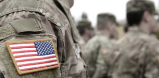 Soldiers in camouflage uniforms with American flag patches.