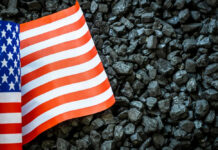 US flag on pile of dark coal rocks