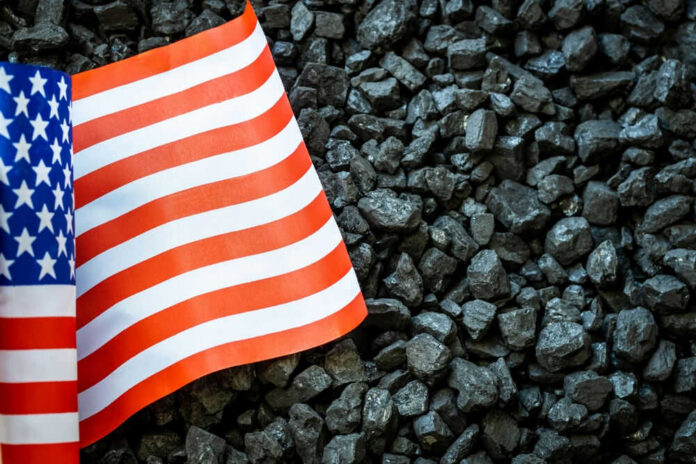 shutterstock_2161696223.jpg US flag on pile of dark coal rocks
