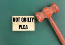 Hollywood MURDER: Son Pleads Not Guilty A wooden gavel next to a sign that reads 'NOT GUILTY PLEA'