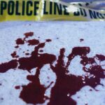 Nine Victims Down In Seconds Blood stains on a surface with police caution tape in the background