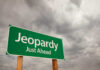 Retail Giant’s Last Stand — 175 Stores in Jeopardy Green road sign indicating 'Jeopardy' ahead with a cloudy sky