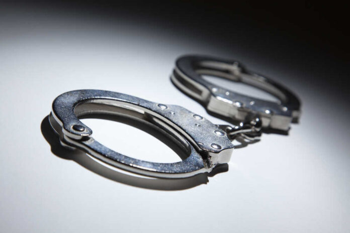 shutterstock_96156656.jpg Close-up of metallic handcuffs on a light surface
