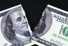 A torn hundred dollar bill featuring Benjamin Franklin