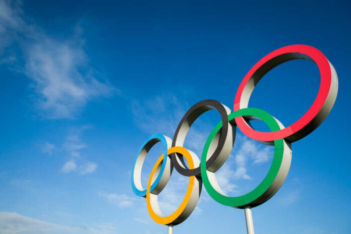 shutterstock_1490338088.jpg Five colorful Olympic rings against a clear blue sky