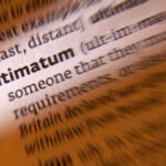 Close-up of a dictionary page showing the definition of 'ultimatum'