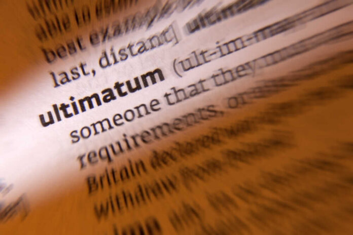 Close-up of a dictionary page showing the definition of 'ultimatum'