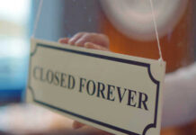 Pizza Chain Shake-Up: 300 Closures Coming Closed forever sign being placed on window.
