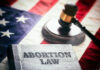 Book titled Abortion Law with gavel and American flag.