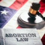 Book titled Abortion Law with gavel and American flag.