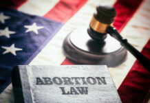 Book titled Abortion Law with gavel and American flag.