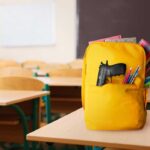Classroom Shooting: Teen Boy Opens Fire A yellow backpack with a gun partially visible in a classroom setting