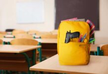 A yellow backpack with a gun partially visible in a classroom setting