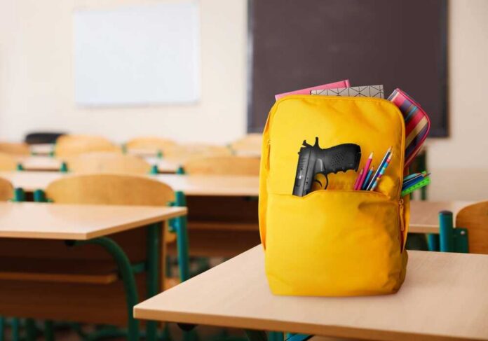 shutterstock_2259387781.jpg A yellow backpack with a gun partially visible in a classroom setting