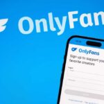 Mobile phone displaying the OnlyFans login screen on a blue background