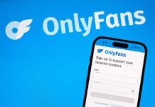 Mobile phone displaying the OnlyFans login screen on a blue background