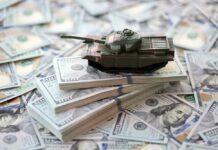 A toy tank placed on stacks of hundred-dollar bills