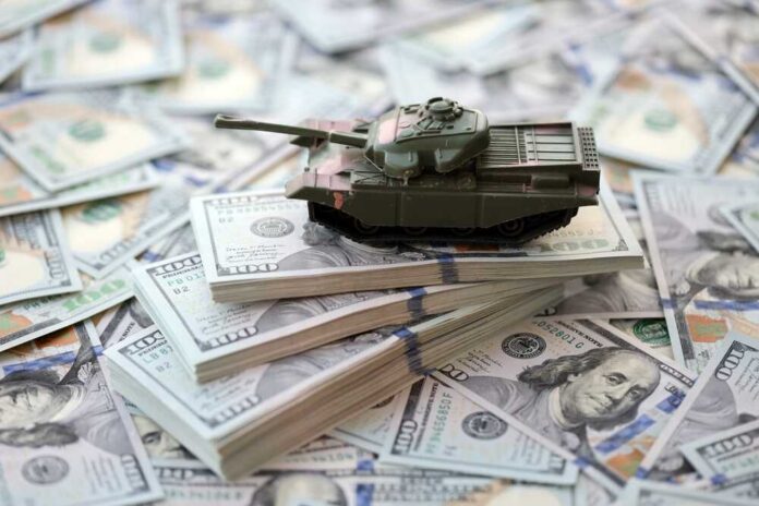 A toy tank placed on stacks of hundred-dollar bills