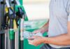 Man holding cash at a gas station
