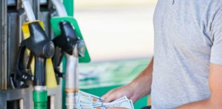 Man holding cash at a gas station