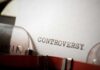 Close-up of a typewriter with the word 'CONTROVERSY' typed on paper