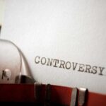 Close-up of a typewriter with the word 'CONTROVERSY' typed on paper