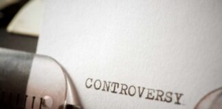 Close-up of a typewriter with the word 'CONTROVERSY' typed on paper