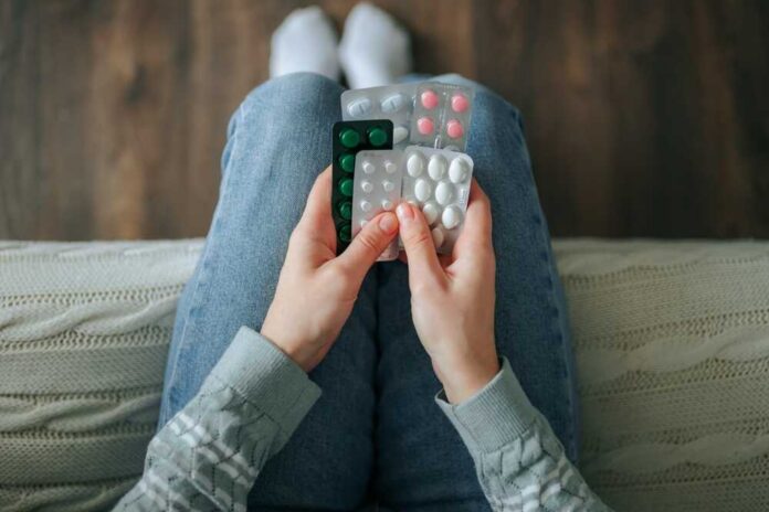 Person holding multiple blister packs of pills