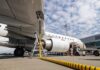 An airplane being fueled at an airport with a visible jet engine