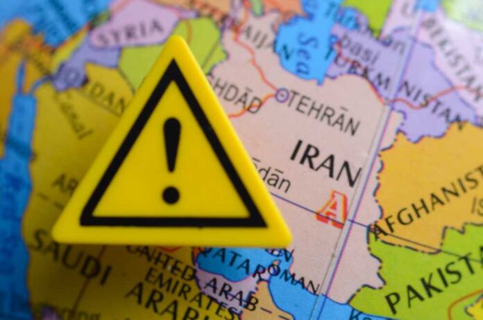 A yellow warning sign placed on a map highlighting Iran