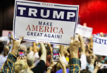 People holding Trump Make America Great Again signs.