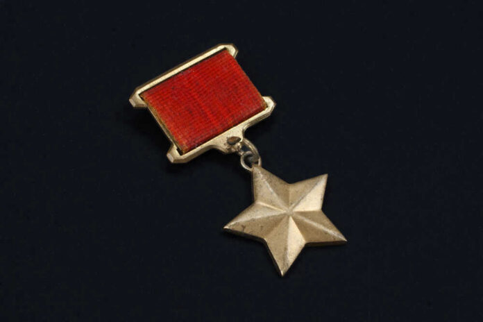 Gold star medal with a red ribbon.