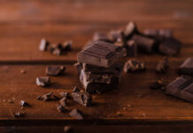 Stack of dark chocolate pieces on a wooden surface